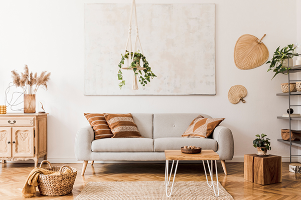 Világos, természetes színekkel berendezett panel nappali, amely skandináv és boho stílusjegyeket ötvöz. A helyiségben egy szürke kanapé, fa kávézóasztal, rattan és fonott dekorációk találhatók. Világos, természetes színekkel berendezett panel nappali, amely skandináv és boho stílusjegyeket ötvöz. A helyiségben egy szürke kanapé, fa kávézóasztal, rattan és fonott dekorációk találhatók.
