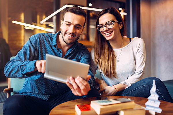 Házfelújítás lépései: fiatal pár régi családi ház felújítását tervezi tableten keresztül